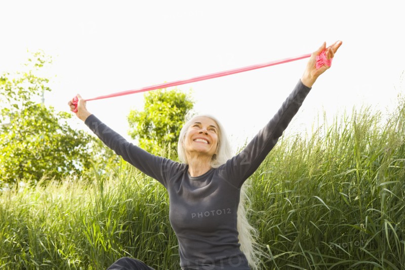 Smiling Caucasian woman stretching with resistance band