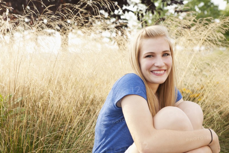 Caucasian teenager sitting in grass