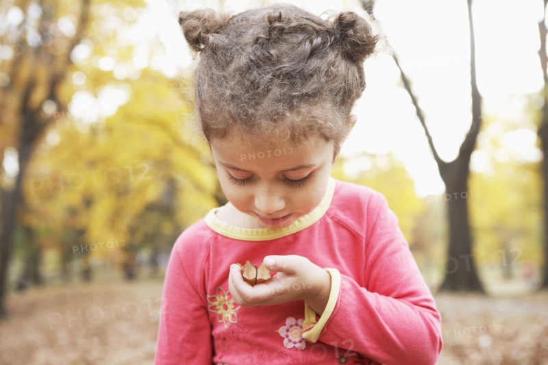 Hispanic girl examining plants outdoors