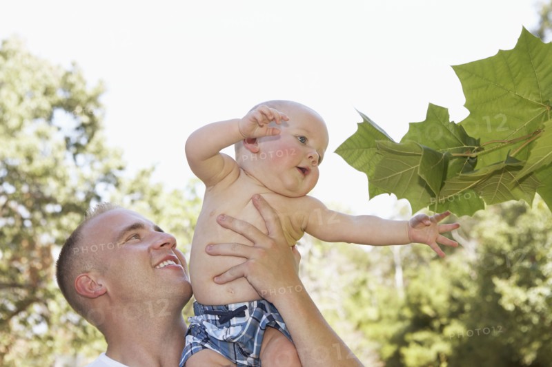 Father holding baby outdoors