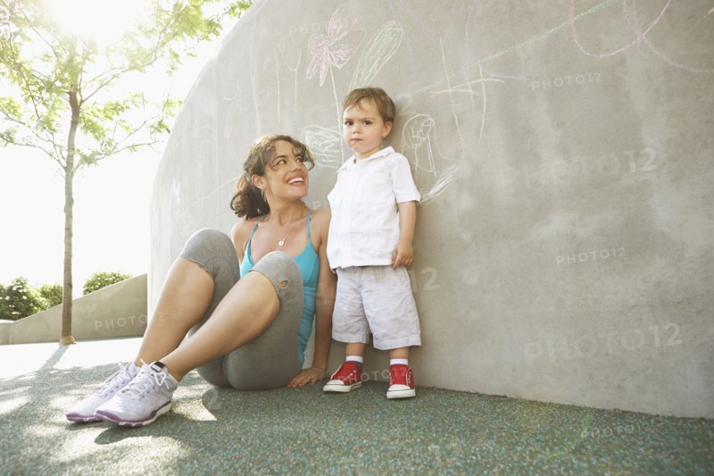 Mixed race mother sitting with son outdoors
