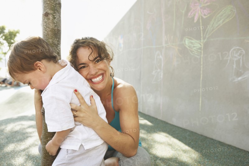 Mixed race mother hugging son outdoors
