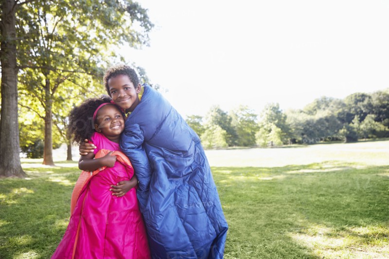 Mixed race children wrapped in sleeping bags