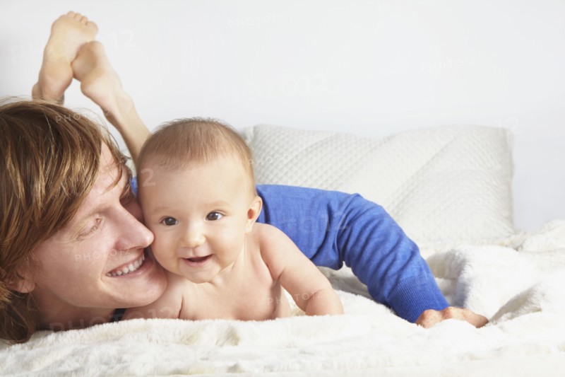 Father and baby laying on blanket