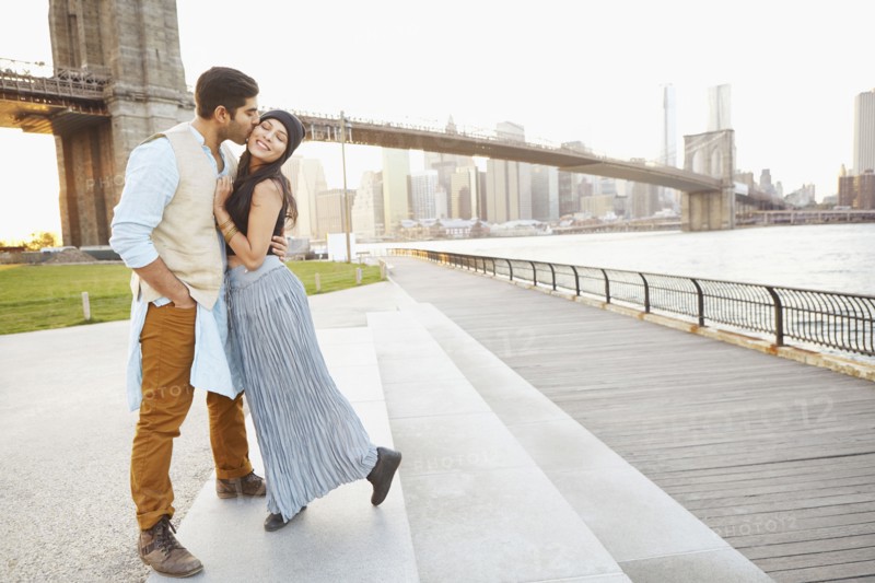 Indian couple kissing by bridge
