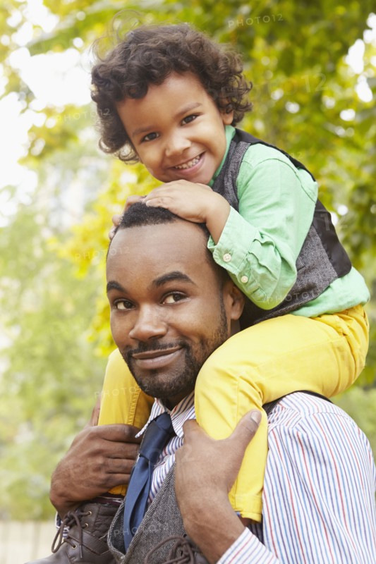Father carrying son in park