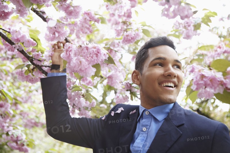 Man in suit walking under flowering tree