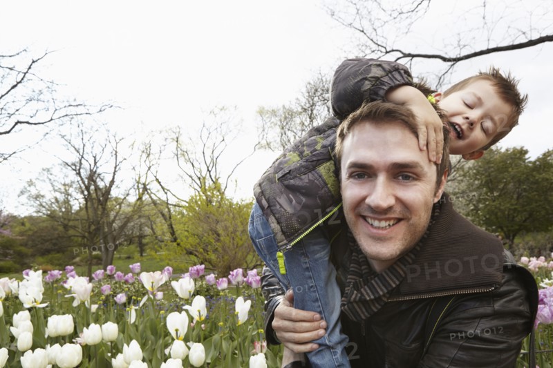 Father carrying son in park