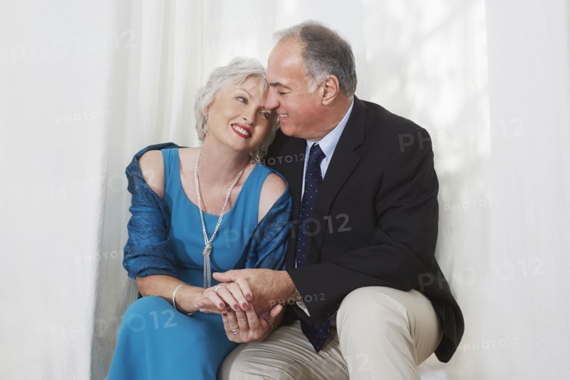 Smiling older couple in formal wear hugging