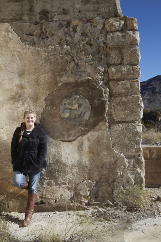 Tourist smiling near relief sculpture on wall of ruins
