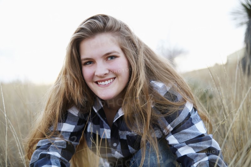 Smiling woman sitting in tall grass