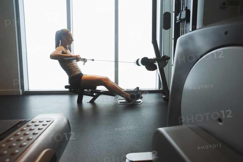 Woman using exercise machine in gym