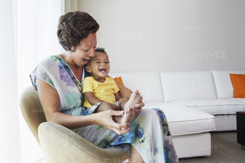 Black mother and son sitting in living room