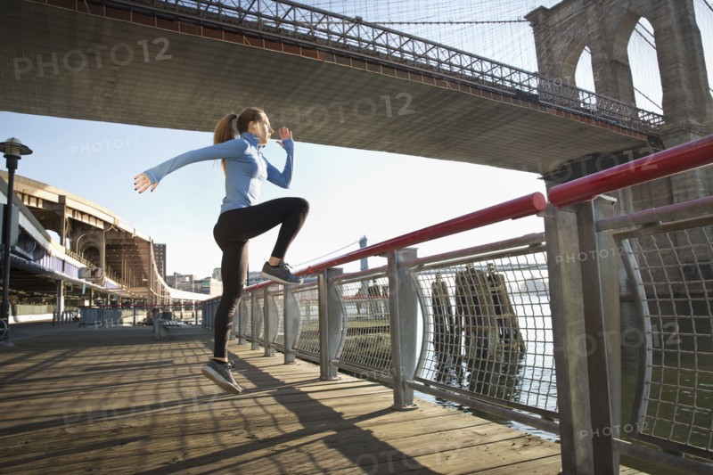 Caucasian runner stretching on waterfront