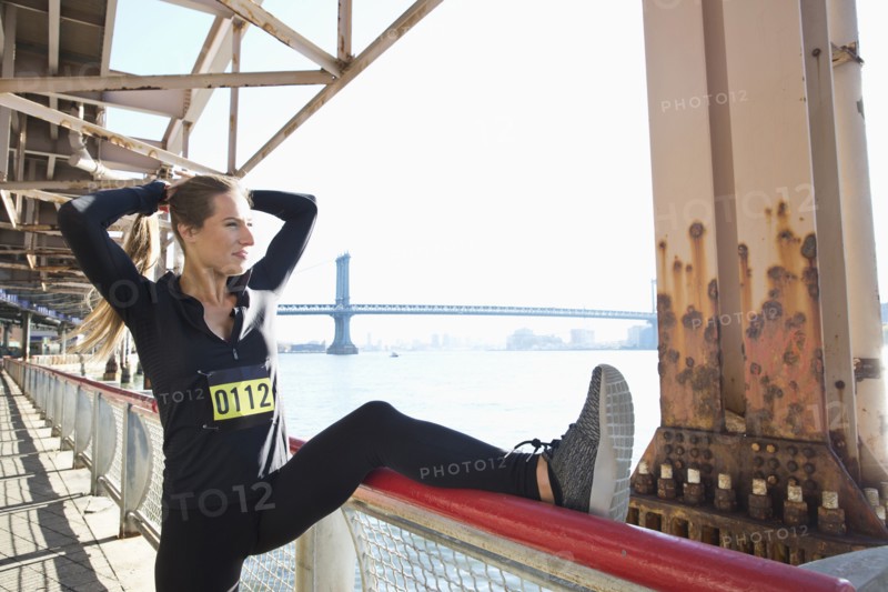 Caucasian runner stretching on waterfront