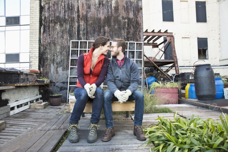 Couple sitting in urban rooftop garden
