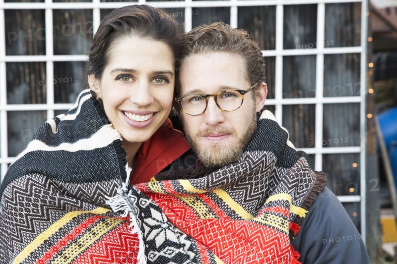 Couple wrapped in blanket outdoors