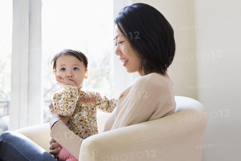 Mother and daughter hugging on sofa