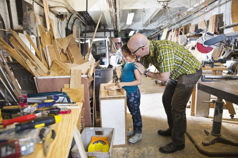 Father and daughter woodworking in workshop