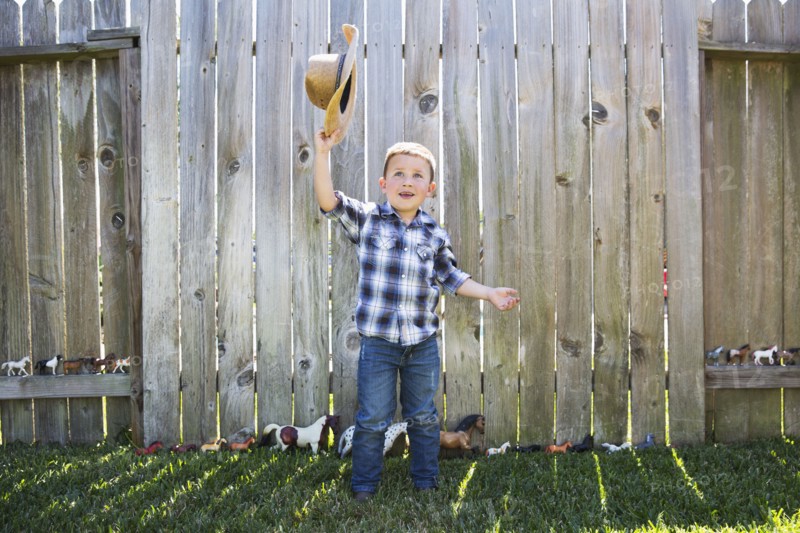 Caucasian boy waving cowboy hat