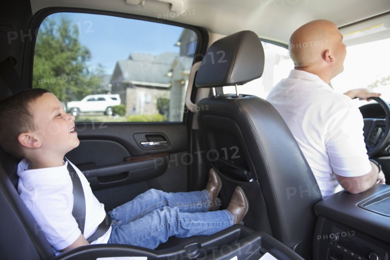 Smiling Caucasian father and son in car