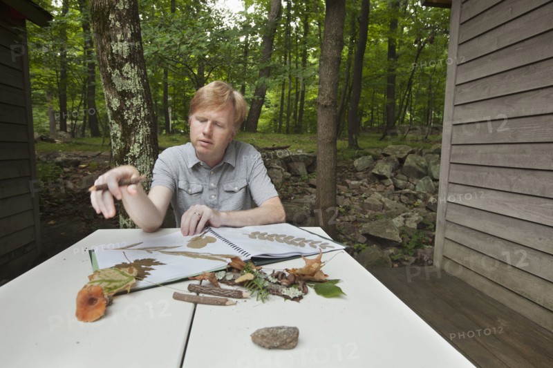 Caucasian man with nature scrapbook outdoors