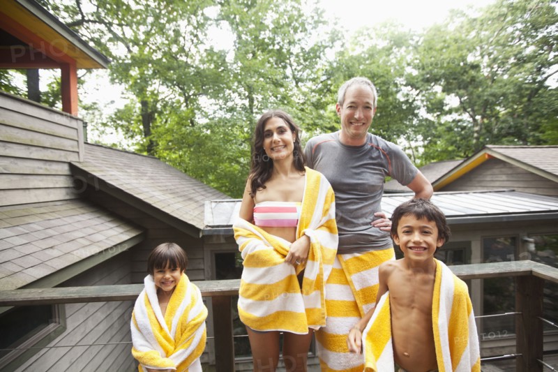 Smiling family wrapped in towels