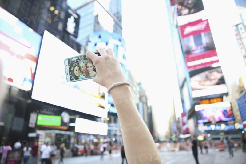 Arm of Caucasian woman posing for cell phone selfie with friends