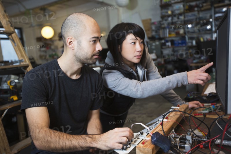 Man and woman working with electronics in workshop