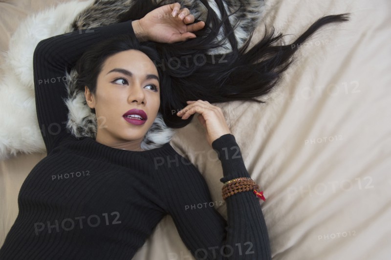 Glamorous transgender Thai woman laying on bed