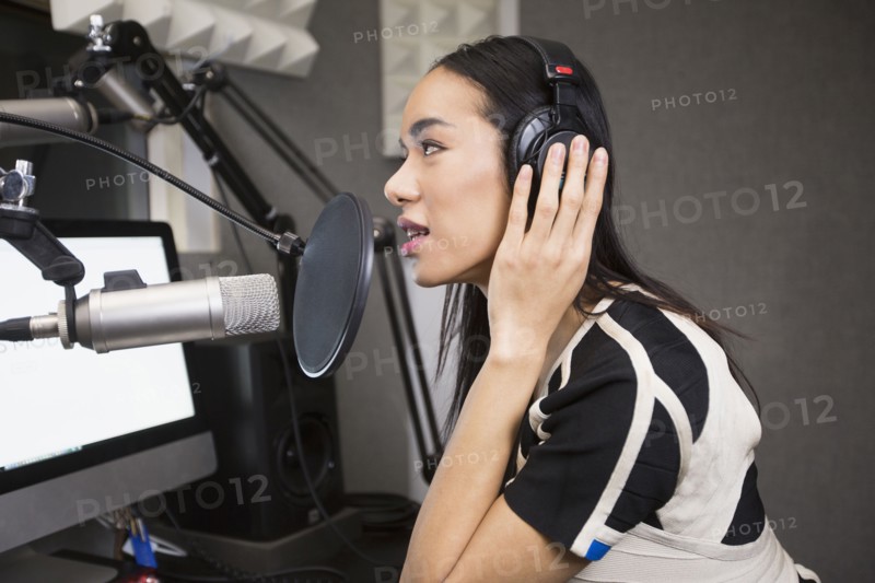 Thai transgender woman using headphones and microphone