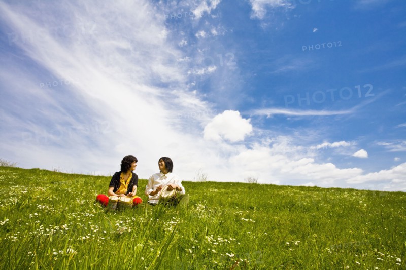 Asian couple playing drums in meadow