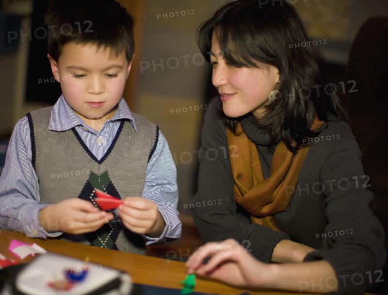 Asian mother and son making origami