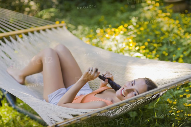 Hispanic woman laying in hammock