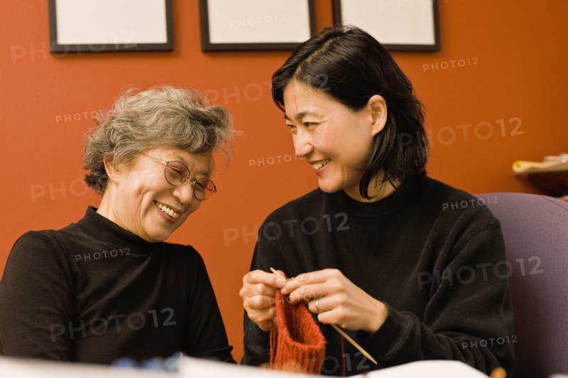 Asian mother and daughter knitting