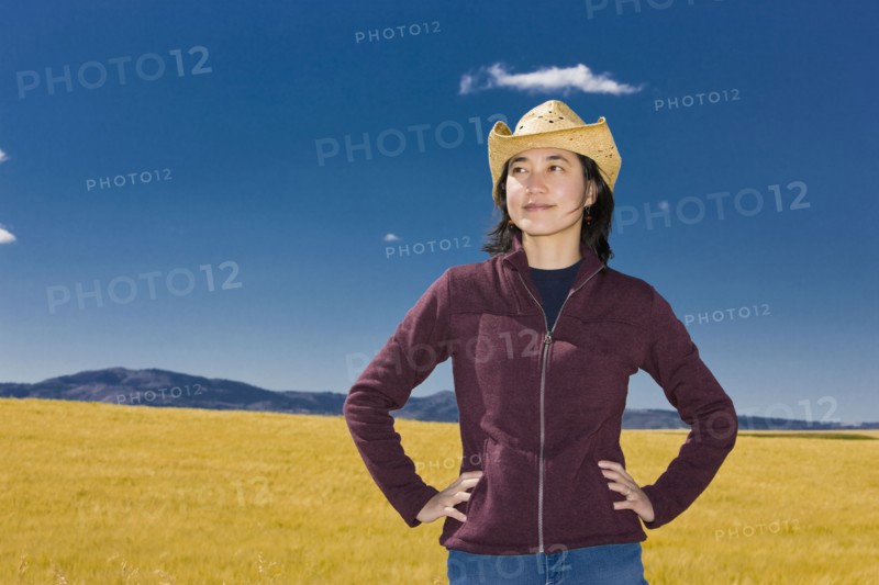 Asian woman standing in remote field