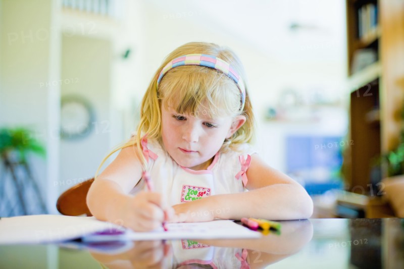 Caucasian girl drawing at table