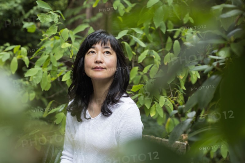 Japanese woman sitting in garden
