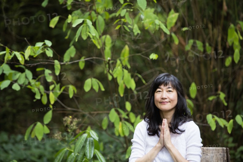 Japanese woman meditating in garden