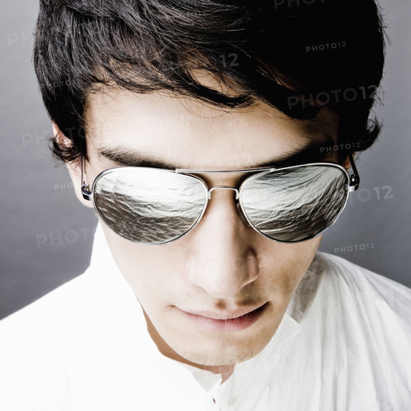 Mixed race man in sunglasses reflecting water