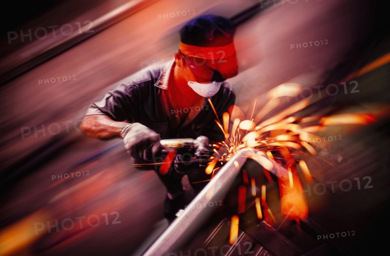 Caucasian welder working on metal pipe