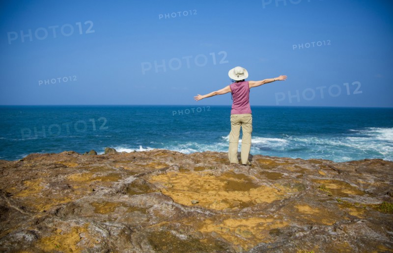 Japanese woman standing on rocky beach