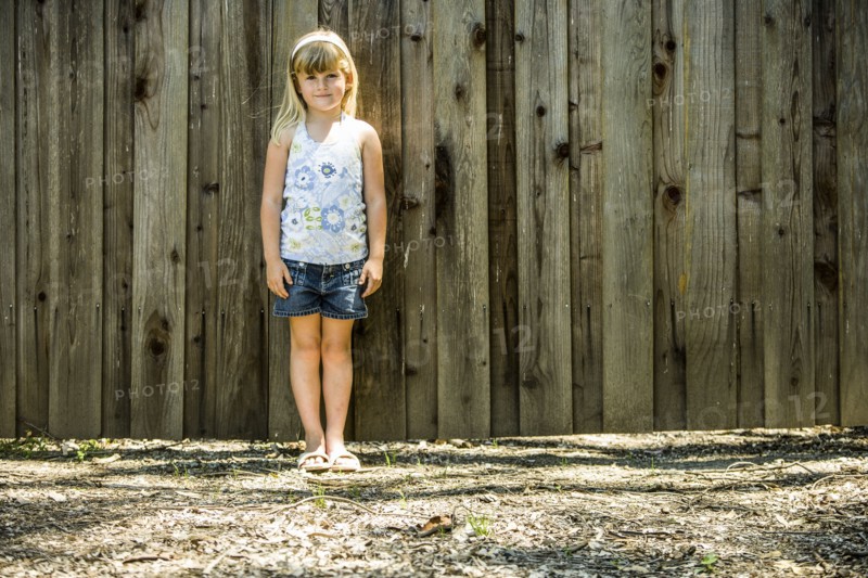 Caucasian girl standing at wooden fence