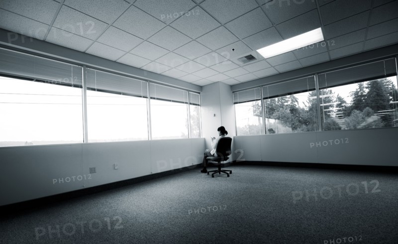 Japanese businesswoman sitting in corner of empty office