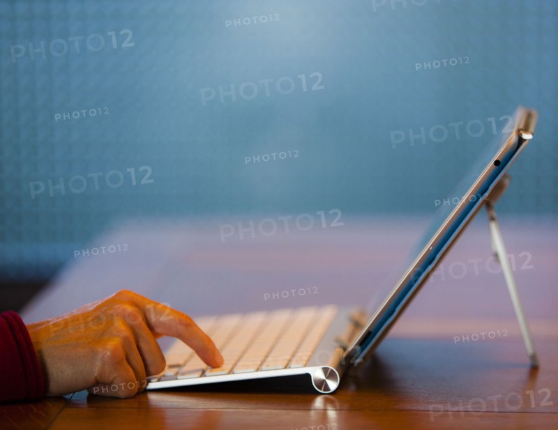 Finger of Japanese woman pressing keyboard for digital tablet