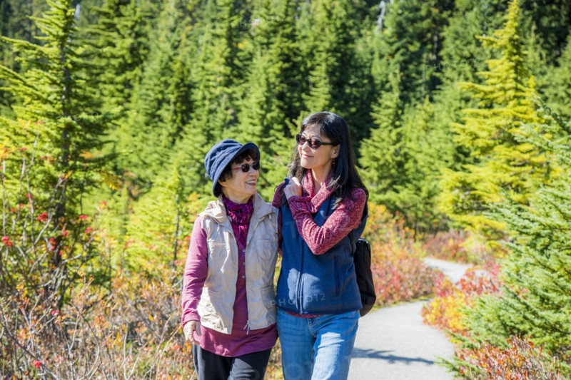 Older Japanese mother and daughter walking on nature path