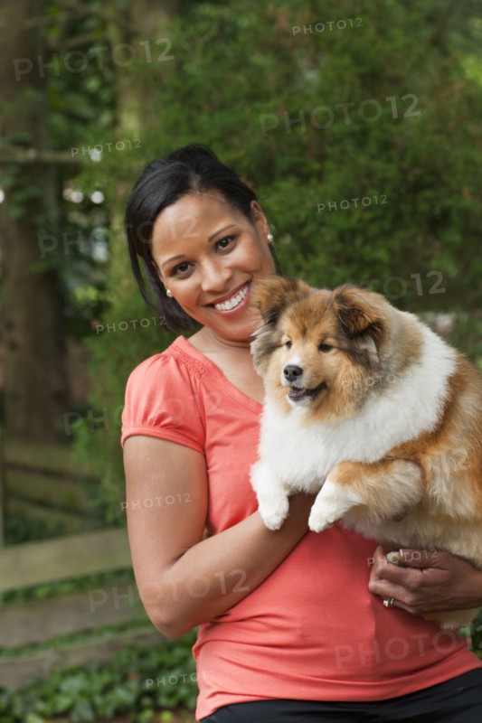 African American woman holding dog