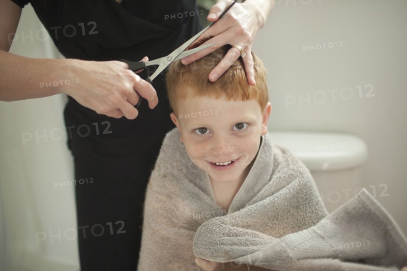 Caucasian mother giving son haircut