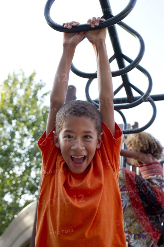 Mixed race boy playing on playground
