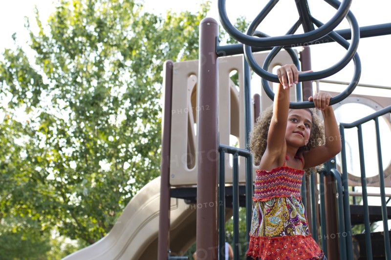 Mixed race girl playing on playground